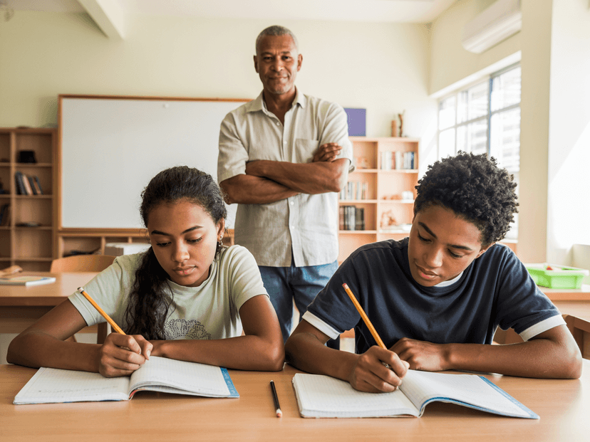 Two teenagers studying together with mentor support